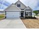 Charming single-Gathering home with a two-car garage and manicured lawn, presenting a welcoming facade at 142 Vega Loop, Sanford, NC 27330