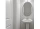 Half bathroom with pedestal sink, oval mirror and decorative lighting at 144 Fideaux Blvd # 251, Raleigh, NC 27603
