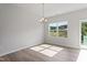 Dining area with chandelier, large windows, wood-look flooring, and access to the backyard through sliding glass door at 144 Fideaux Blvd # 251, Raleigh, NC 27603