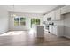 Bright kitchen featuring white cabinetry, stainless steel appliances, island with sink, and sliding glass doors at 144 Fideaux Blvd # 251, Raleigh, NC 27603