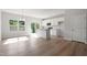 Open-concept kitchen with white cabinets, stainless steel appliances, granite countertops, and wood-look flooring at 144 Fideaux Blvd # 251, Raleigh, NC 27603