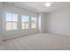 Large main bedroom featuring three windows, neutral carpet, a ceiling fan, and neutral paint at 144 Fideaux Blvd # 251, Raleigh, NC 27603