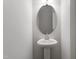 Elegant pedestal sink with oval mirror and modern lighting in well-lit bathroom at 148 Fideaux Blvd # 250, Raleigh, NC 27603