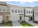 Stylish townhome exteriors featuring a modern design, garages, and neat landscaping on a partly cloudy day at 148 Fideaux Blvd # 250, Raleigh, NC 27603