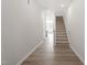 Bright hallway featuring wood floors, white walls, and carpeted stairs leading to the upper level at 148 Fideaux Blvd # 250, Raleigh, NC 27603