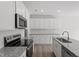 Well-equipped kitchen featuring granite countertops, stainless steel appliances, white cabinetry, and wood flooring at 148 Fideaux Blvd # 250, Raleigh, NC 27603