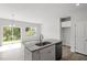 Kitchen island with granite countertop, stainless steel sink, and dishwasher in an open floor plan at 148 Fideaux Blvd # 250, Raleigh, NC 27603