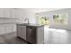 Kitchen island with stainless steel dishwasher and sink, complemented by white cabinets and sliding glass doors at 148 Fideaux Blvd # 250, Raleigh, NC 27603