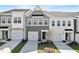 Townhome exterior featuring multi-car garage, well-manicured lawn, and neutral color palette at 152 Fideaux Blvd # 249, Raleigh, NC 27603