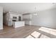 Kitchen and living area with island, white cabinets, and wood flooring at 152 Fideaux Blvd # 249, Raleigh, NC 27603
