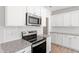 Close-up of a modern kitchen featuring stainless steel appliances, granite countertops, and tiled backsplash at 152 Fideaux Blvd # 249, Raleigh, NC 27603