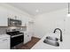 Modern kitchen featuring stainless steel appliances, white cabinets, gray backsplash, and a deep sink at 30 Rosewood Ln, Youngsville, NC 27596