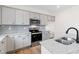 Modern kitchen with gray cabinets, granite countertops, and a black faucet at 30 Rosewood Ln, Youngsville, NC 27596