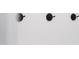 Close up of black coat hooks on white beadboard in a mudroom next to a doorway at 30 Rosewood Ln, Youngsville, NC 27596
