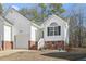 Brick and white exterior home with a two-car garage and landscaping at 3018 E Cotton Gin Dr, Clayton, NC 27527