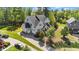 Aerial view of a gray home with three-car garage, spacious yard and lush green surroundings at 3308 Eden Grove Rd, Fuquay Varina, NC 27526