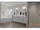 A bright bathroom features double sinks, white cabinets, soaking tub, and tile shower at 3308 Eden Grove Rd, Fuquay Varina, NC 27526