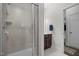 Clean bathroom featuring a shower, tile surround, dark wood vanity with a white sink, and a gray and white rug at 3308 Eden Grove Rd, Fuquay Varina, NC 27526