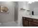 Bathroom featuring wood cabinets, a framed mirror, a framed art piece, a walk-in shower with glass door, and light walls at 3308 Eden Grove Rd, Fuquay Varina, NC 27526