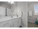 Bright bathroom featuring white vanity, mirror, and tiled flooring with natural light at 3308 Eden Grove Rd, Fuquay Varina, NC 27526