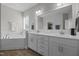 Bright bathroom features double sinks, white cabinets, soaking tub, and ample mirror at 3308 Eden Grove Rd, Fuquay Varina, NC 27526