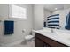 This full bathroom features a sink, toilet, and shower with a blue striped curtain at 3308 Eden Grove Rd, Fuquay Varina, NC 27526