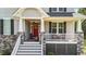 Close up front porch view of house with a vibrant red door and welcoming chairs and décor at 3308 Eden Grove Rd, Fuquay Varina, NC 27526