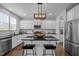 Bright kitchen with white cabinets, island with seating, stainless steel appliances, and hardwood floors at 3308 Eden Grove Rd, Fuquay Varina, NC 27526