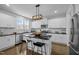 Well-lit kitchen boasts white cabinets, stainless steel appliances, and an island with bar seating at 3308 Eden Grove Rd, Fuquay Varina, NC 27526