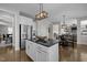 Spacious kitchen with stainless steel appliances, white cabinets, large island with dark countertop, and hardwood flooring at 3308 Eden Grove Rd, Fuquay Varina, NC 27526