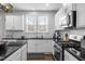 Modern kitchen features white cabinets, granite countertops, stainless steel appliances, and a window providing natural light at 3308 Eden Grove Rd, Fuquay Varina, NC 27526