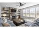 Spacious living room with stone fireplace, floating shelves, recessed lights, large windows, and hardwood floors at 3308 Eden Grove Rd, Fuquay Varina, NC 27526