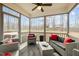 Inviting sunroom with screened windows, comfortable seating, ceiling fan, and a view of the backyard at 3308 Eden Grove Rd, Fuquay Varina, NC 27526