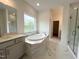Bright bathroom with soaking tub, glass shower, and modern vanity with marble tile at 4408 Emeline Way # 34, Fuquay Varina, NC 27526