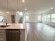 Bright kitchen with stainless steel appliances, pendant lighting, and an open floor plan with luxury vinyl plank flooring at 4408 Emeline Way # 34, Fuquay Varina, NC 27526