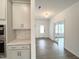 Modern kitchen with white cabinets, light countertops, stainless steel appliances, and view of the front door at 4408 Emeline Way # 34, Fuquay Varina, NC 27526