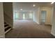 Spacious living room with carpet, bright light, windows and access to the outside, complemented by a staircase at 4408 Emeline Way # 34, Fuquay Varina, NC 27526