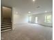 Expansive carpeted living room bathed in natural light, features staircase and easy access to outdoor spaces at 4408 Emeline Way # 34, Fuquay Varina, NC 27526