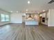 Spacious living room with wood floors and natural light, adjacent to a modern kitchen at 4408 Emeline Way # 34, Fuquay Varina, NC 27526
