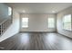 Spacious living room area with LVP floors, staircase, and an abundance of natural light from multiple windows at 4408 Emeline Way # 34, Fuquay Varina, NC 27526