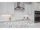 Bright kitchen features white cabinets, stylish backsplash, and stainless steel appliances at 54 Cultivator Ct, Angier, NC 27501