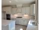 Modern kitchen with white cabinets, stainless steel appliances, and quartz countertops at 54 Cultivator Ct, Angier, NC 27501