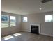 Cozy living room featuring a modern fireplace, hardwood floors, and bright windows at 54 Cultivator Ct, Angier, NC 27501