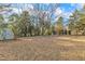 Expansive backyard featuring lush trees and foliage, plus a utility shed, offering a private outdoor retreat at 704 Sunnybrook Rd, Raleigh, NC 27610