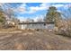 Grey home backyard with a large yard and mature trees at 704 Sunnybrook Rd, Raleigh, NC 27610