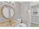 Bathroom featuring a round framed mirror, a tile floor, a sink and natural light from the window at 704 Sunnybrook Rd, Raleigh, NC 27610