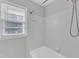 Bathroom featuring a bathtub, tile walls, white trim and a window to allow in natural light at 704 Sunnybrook Rd, Raleigh, NC 27610