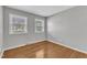Empty bedroom with hardwood floors, large double windows with blinds, and neutral walls at 704 Sunnybrook Rd, Raleigh, NC 27610