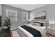 Virtually staged bedroom with a queen bed, neutral walls and two windows to allow for natural light at 704 Sunnybrook Rd, Raleigh, NC 27610