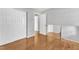 Bedroom features hardwood floors, white trim, mirrored walls, and closet at 704 Sunnybrook Rd, Raleigh, NC 27610